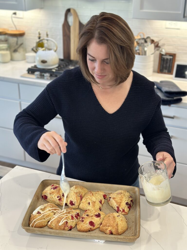 woman putting frosting in scones