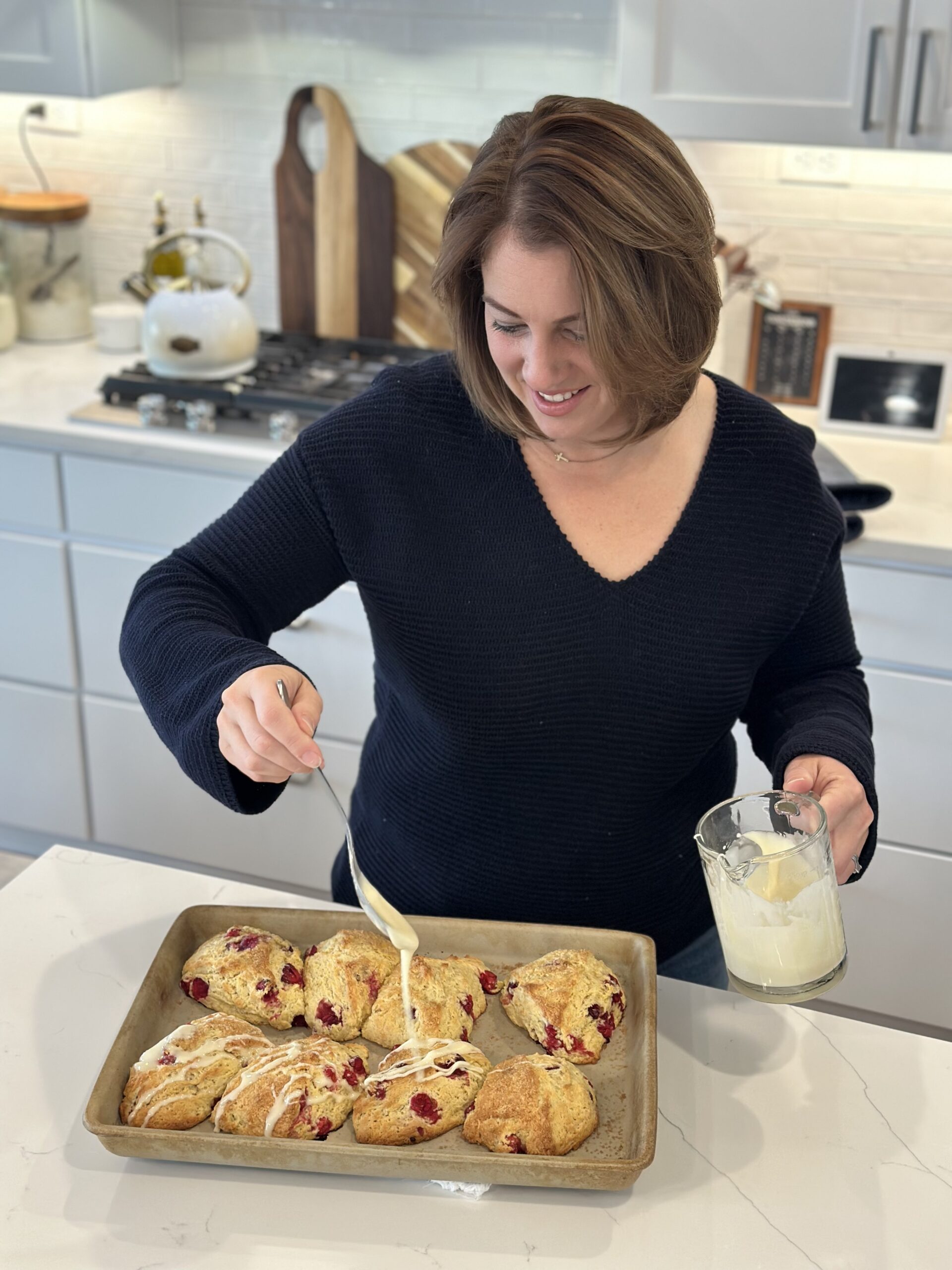 woman putting frosting on scones