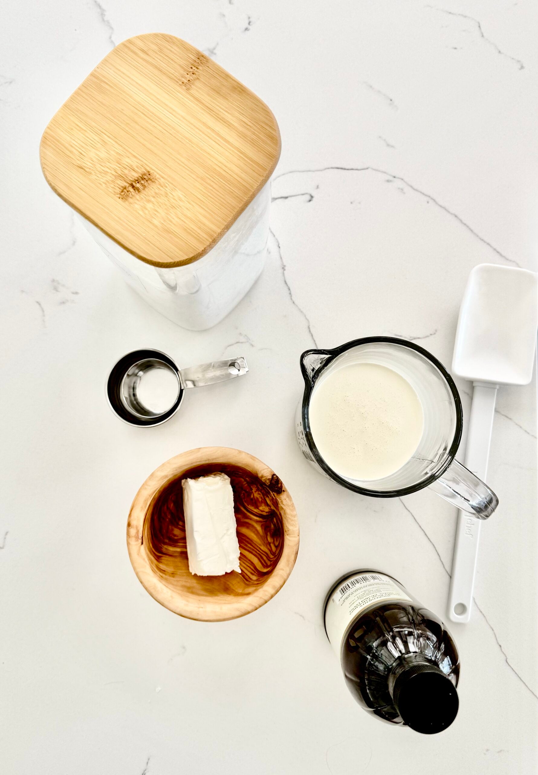 powdered sugar, cream, cream cheese, vanilla with a spatula and measuring cups