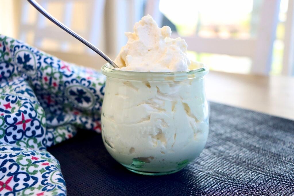 Stabilized Whipped Cream in a glass jar with a colorful towel