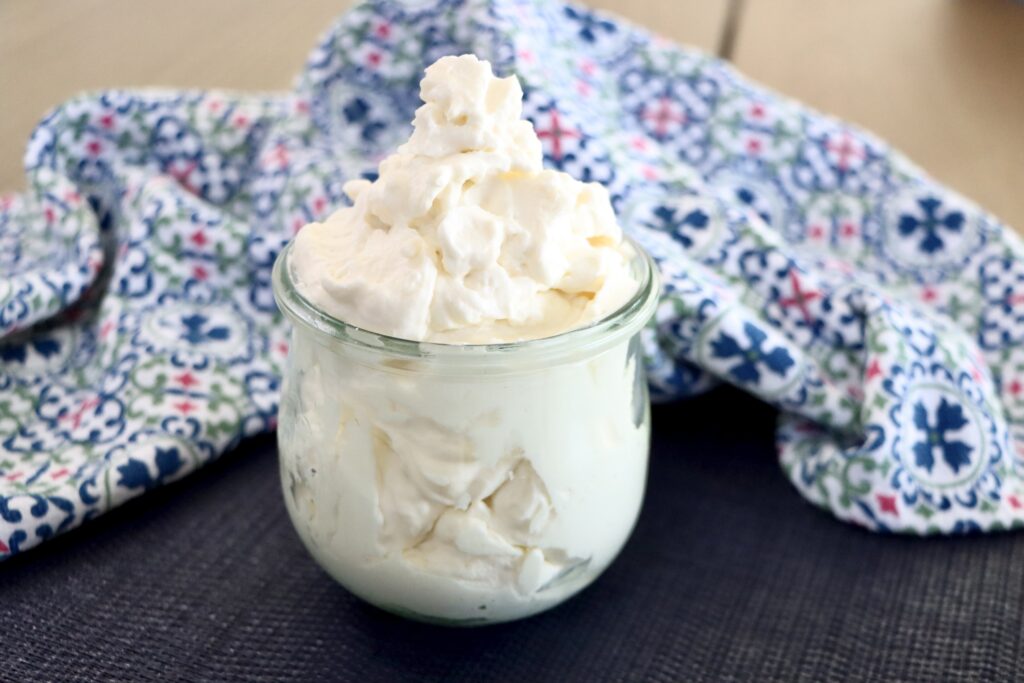 Stabilized Whipped Cream in a glass jar with a colorful towel
