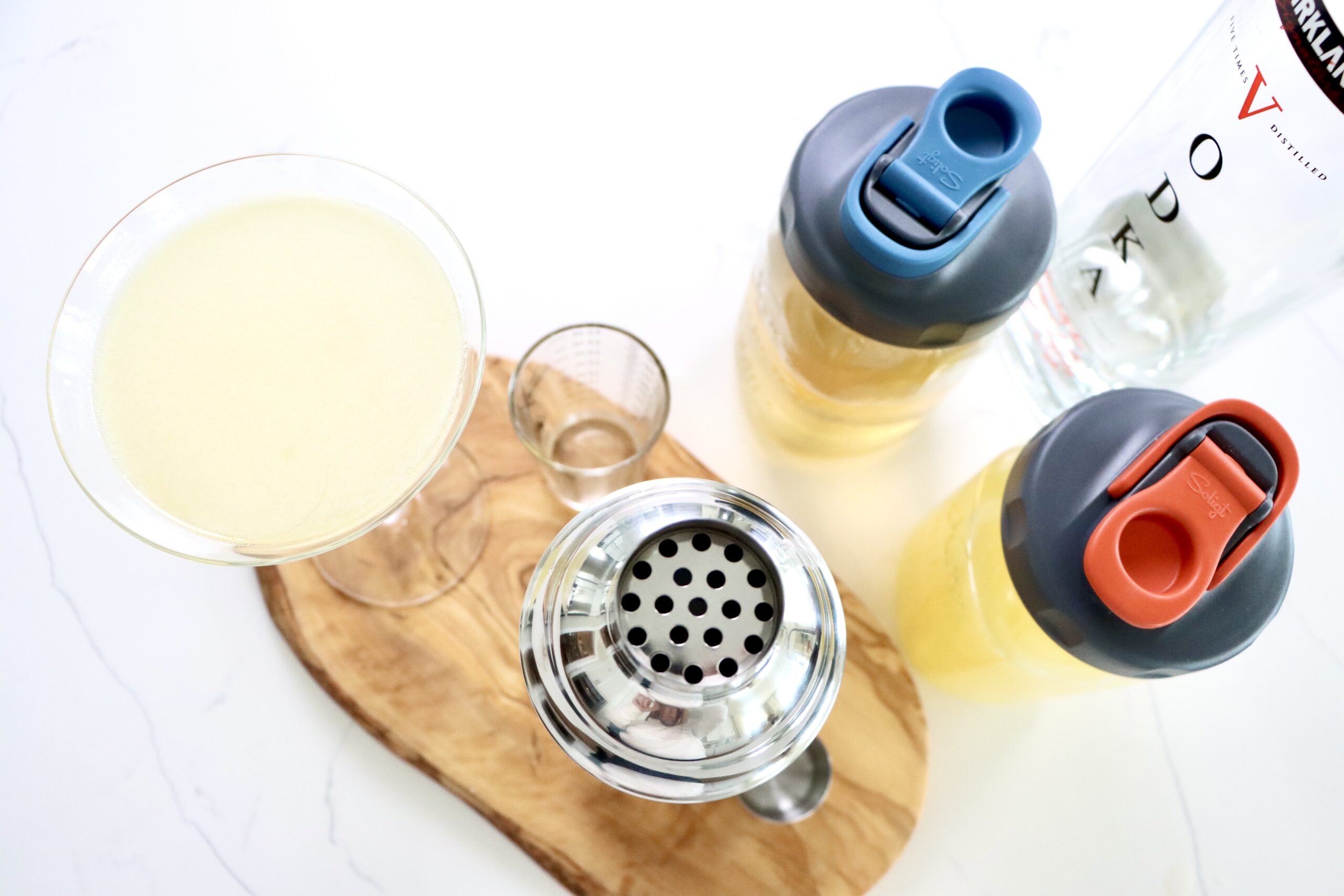 Lemon Drop Martini with a shaker, and jars of lemon juice and simple syrup along with vodka