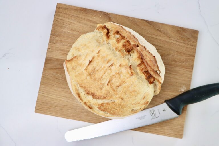 a loaf of sourdough bread on a cutting board with a knife