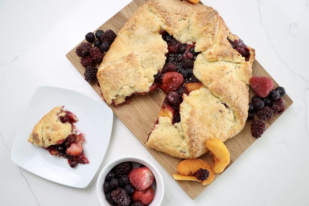 Rustic Berry Peach Galette on a cutting board with fruit