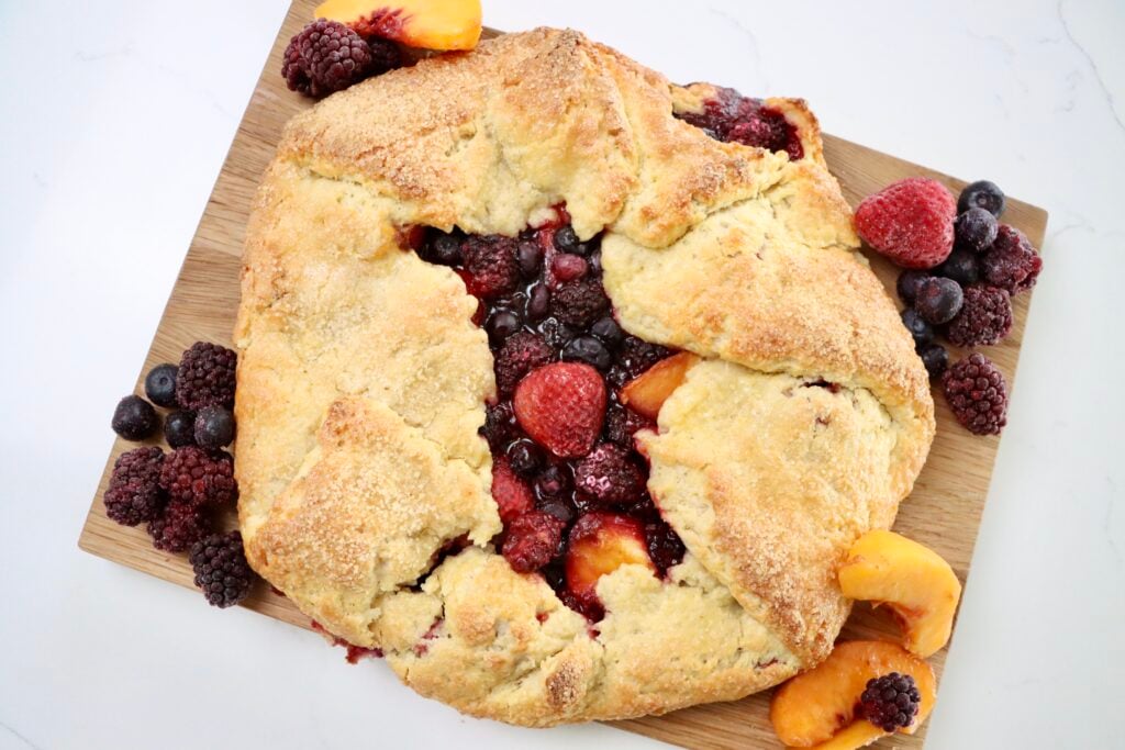 Rustic Berry Peach Galette on a cutting board with fruit