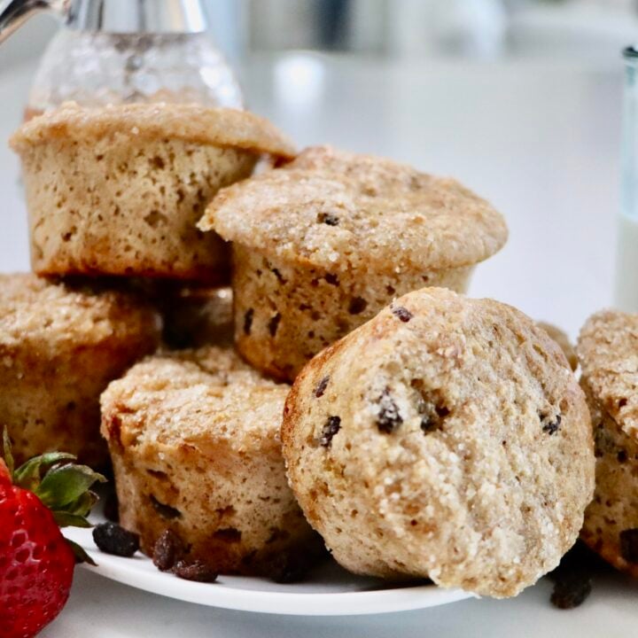 Whole Wheat Yogurt Muffins on a plate with a glass of milk and a jar of honey