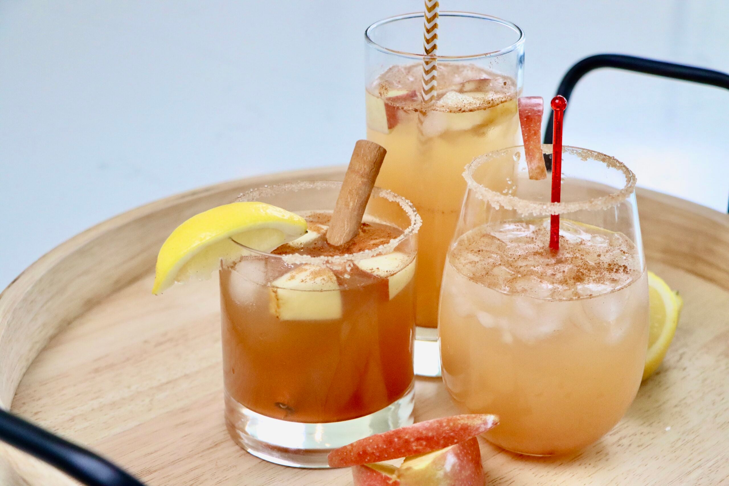 Three glasses of sparkling apple cider on a drink tray