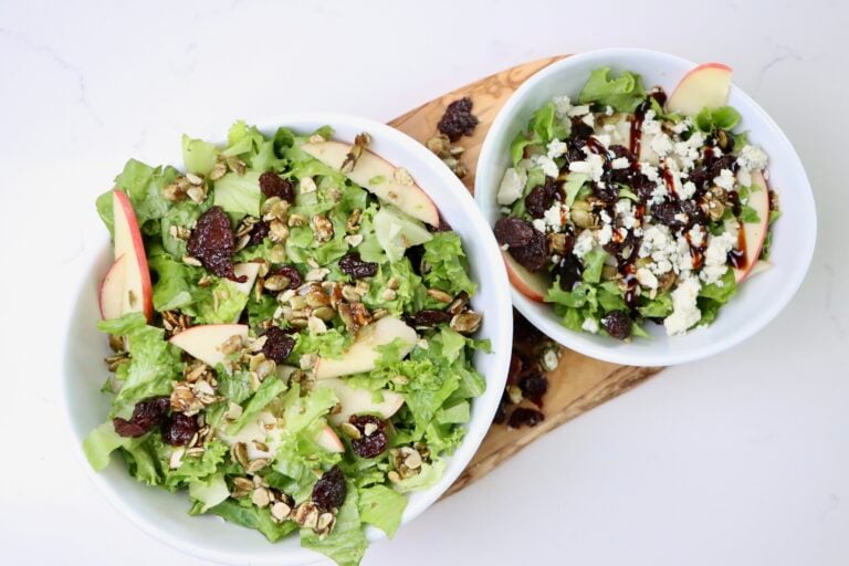Two Winter Salads in a bowl on a cutting board