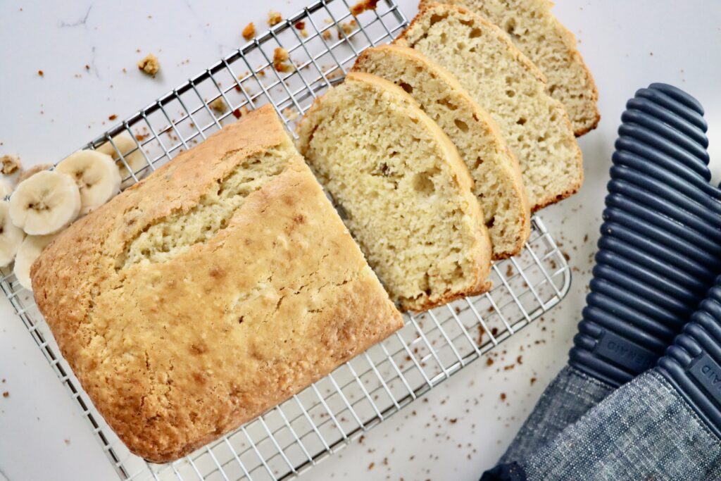 Freshly baked homemade banana bread loaf on a cooling rack, made from scratch with real ingredients.