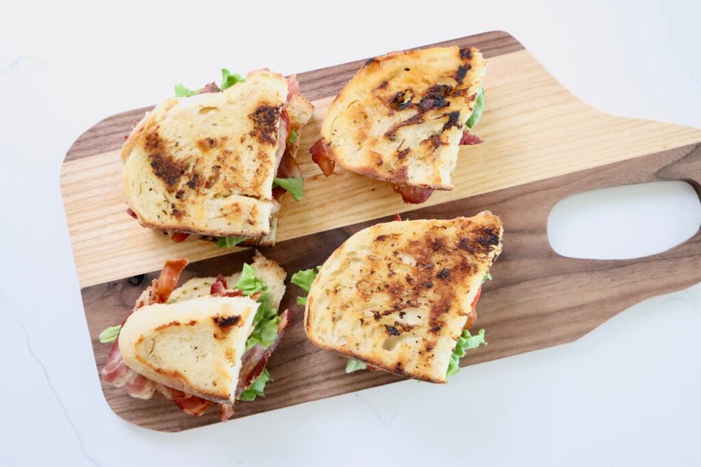 BLT Sandwich on homemade sourdough bread with homemade herb mayo sitting on a cutting board
