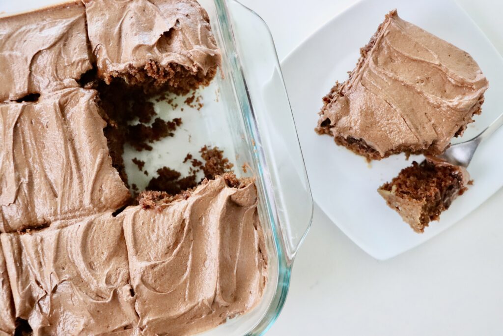Moist Chocolate Zucchini Cake frosted with Chocolate Buttercream Frosting sliced in a pan
