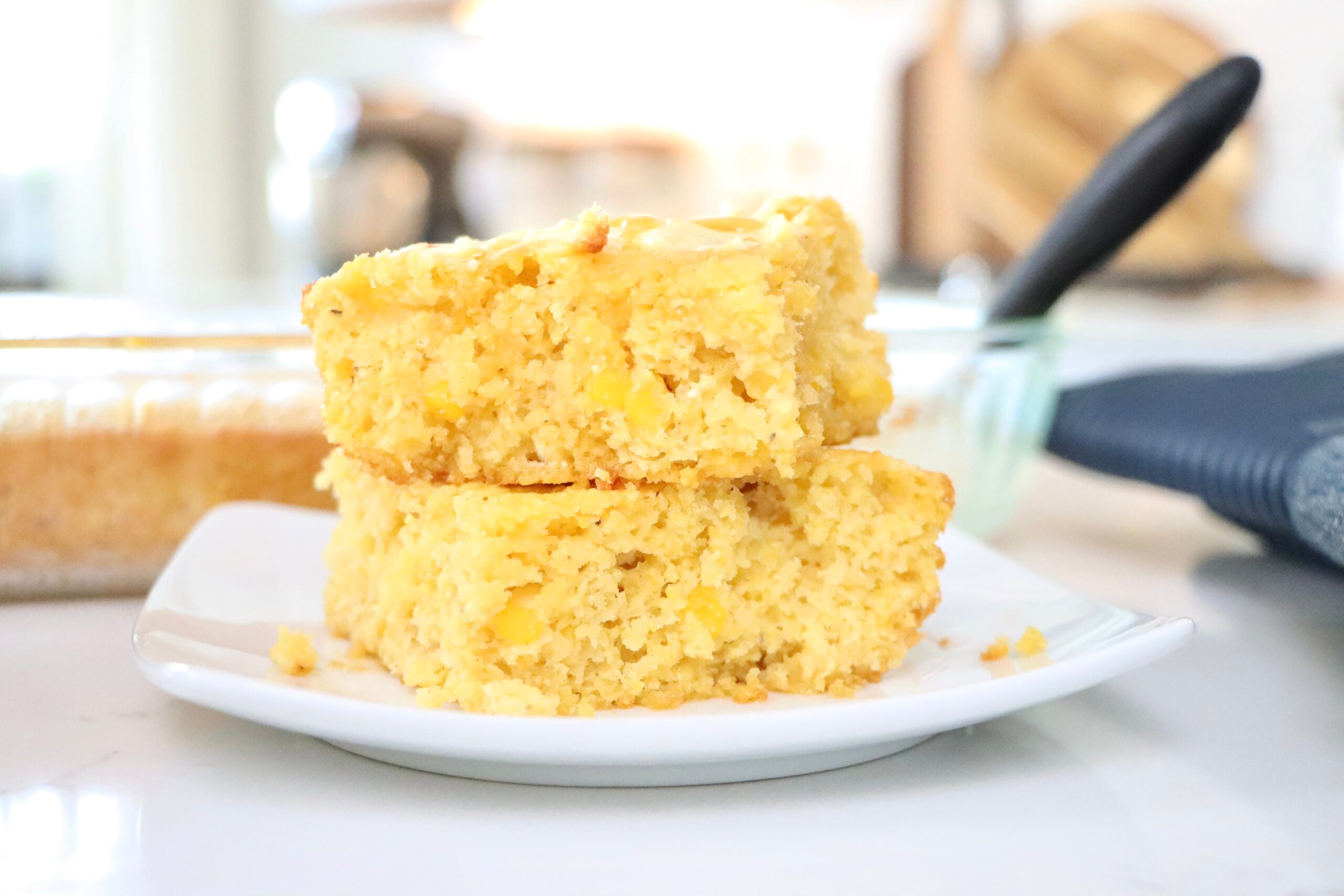 Moist Einkorn Cornbread stacked on a plate and in a pan.