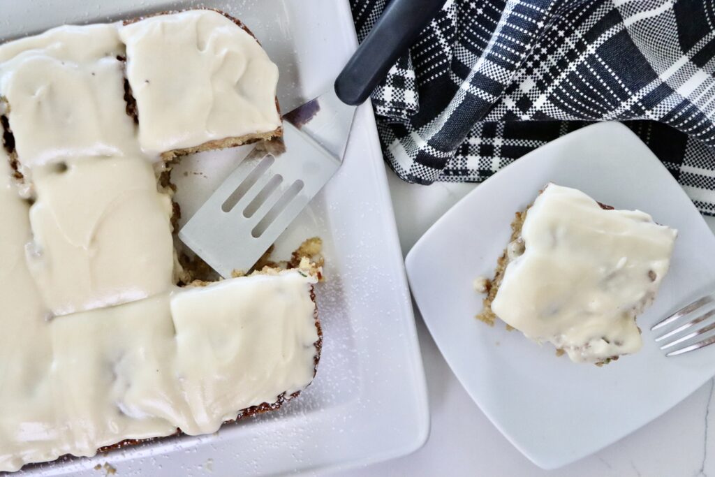 Overhead view of pineapple zucchini cake cut into squares, baked in a 9x13 pan with golden crust.