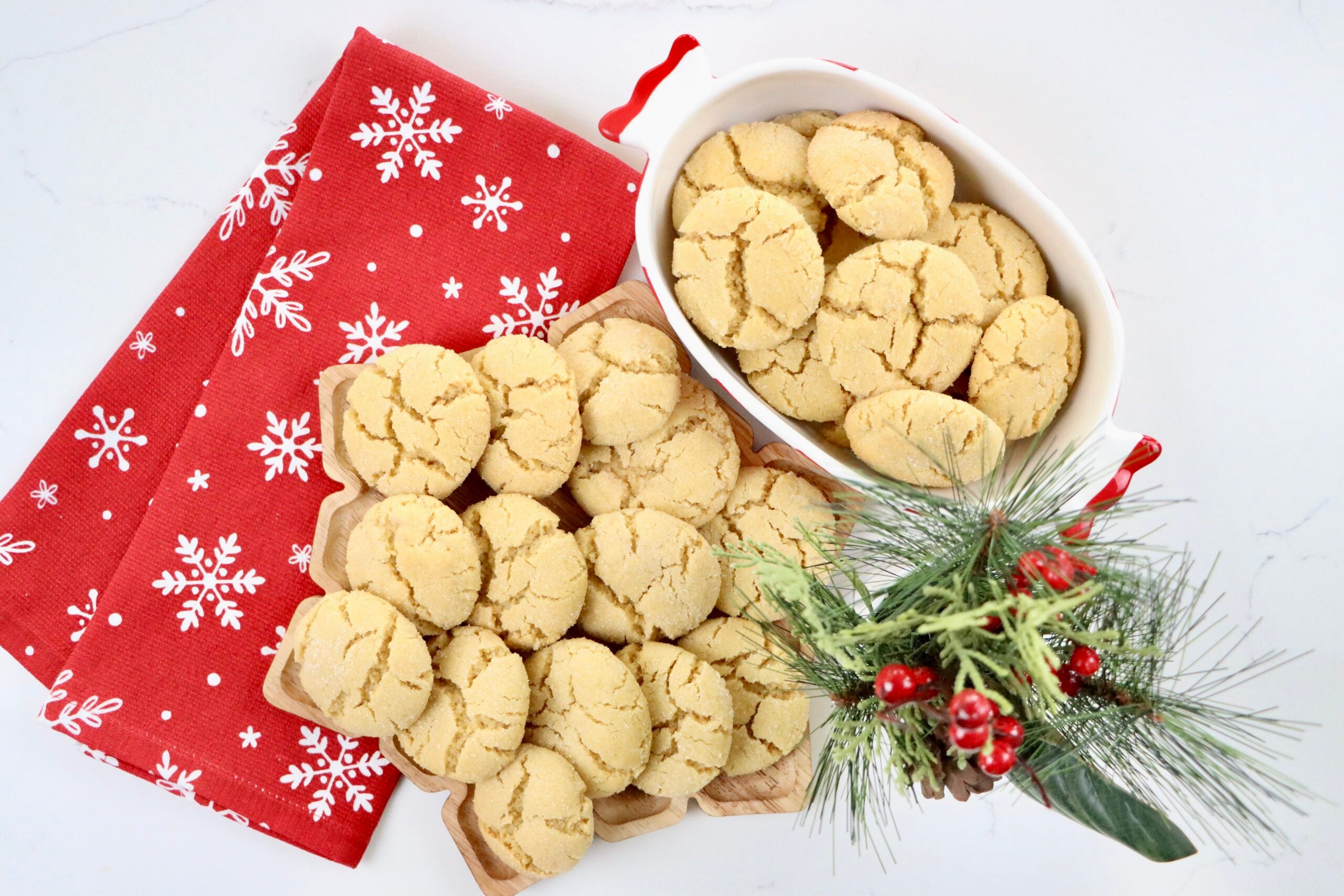 Soft, buttery Angel Cookies on a snowflake tray and bowl with golden edges and sparkling sugar coating
