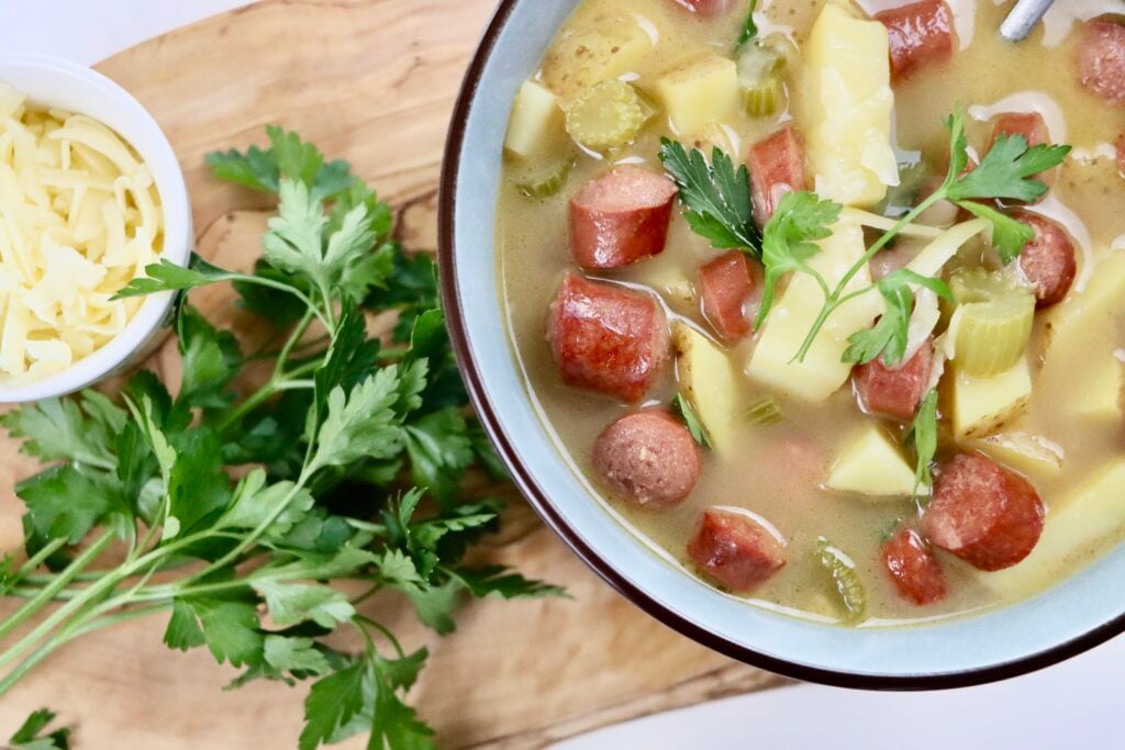 Bowl of creamy hotdog potato soup with golden potatoes, sliced hotdogs, and fresh parsley on top