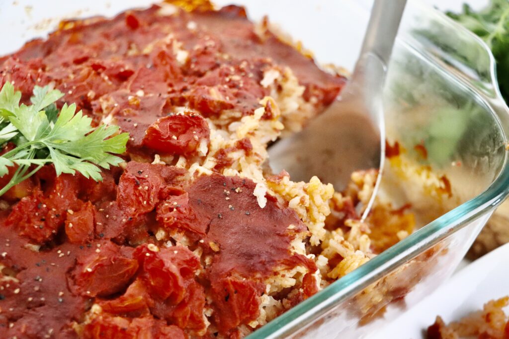 Close-up of Spanish-style beef and rice casserole showing layers of beef, rice, and tomatoes.