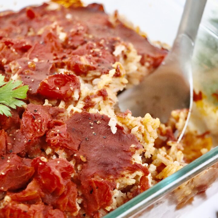 Close-up of Spanish-style beef and rice casserole showing layers of beef, rice, and tomatoes.