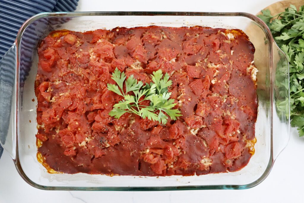 Close-up of Spanish-style beef and rice casserole showing layers of beef, rice, and tomatoes.