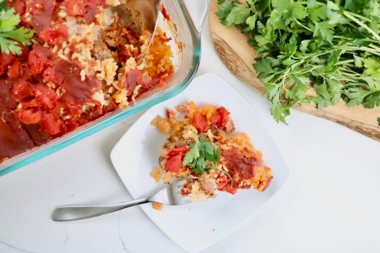 Close-up of Spanish-style beef and rice casserole showing layers of beef, rice, and tomatoes.