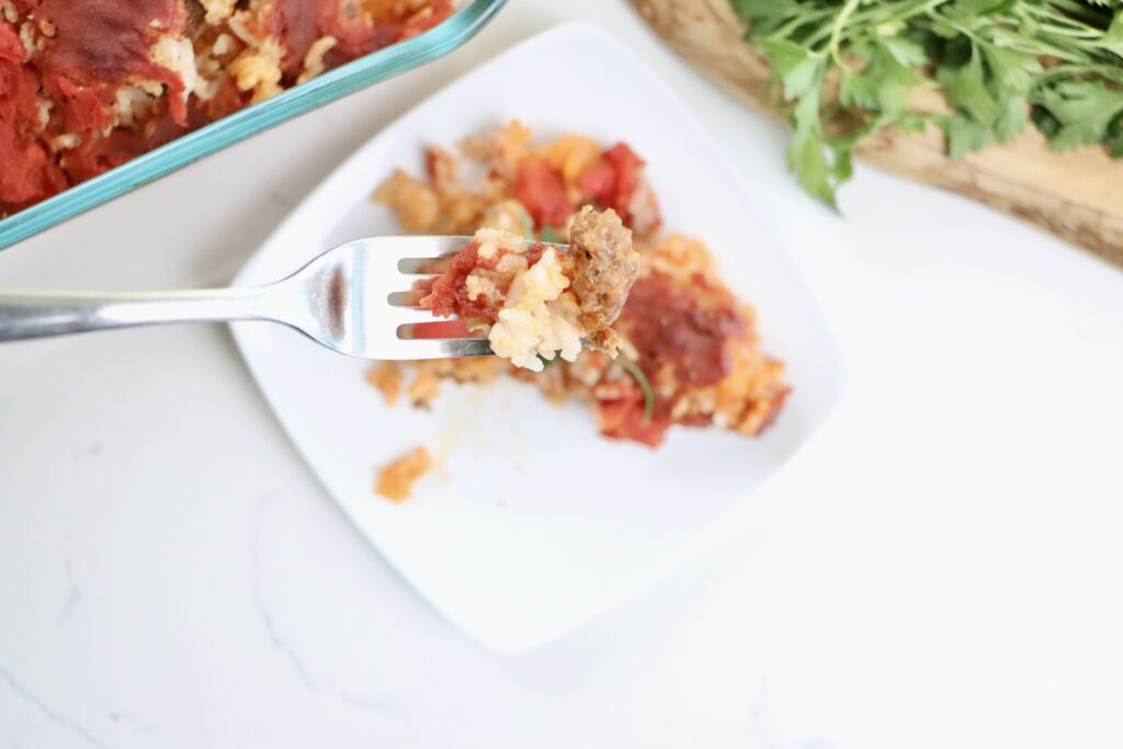 Close-up of Spanish-style beef and rice casserole showing layers of beef, rice, and tomatoes.