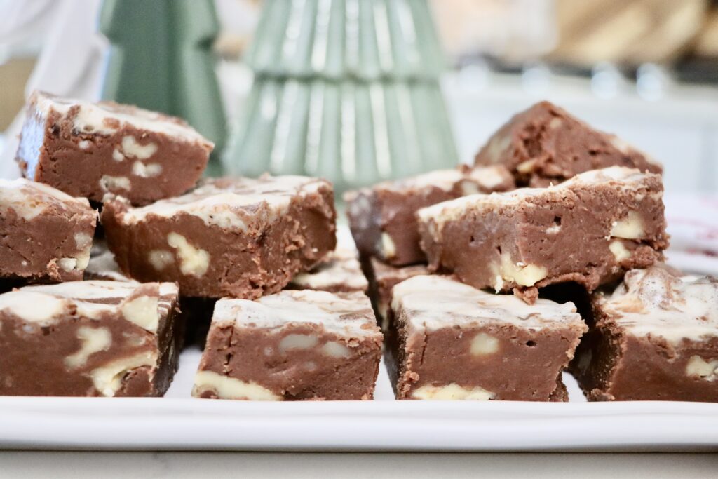 Homemade honey maple marshmallow fudge with walnuts cut into squares on a white tray — rich, creamy, and made from scratch.