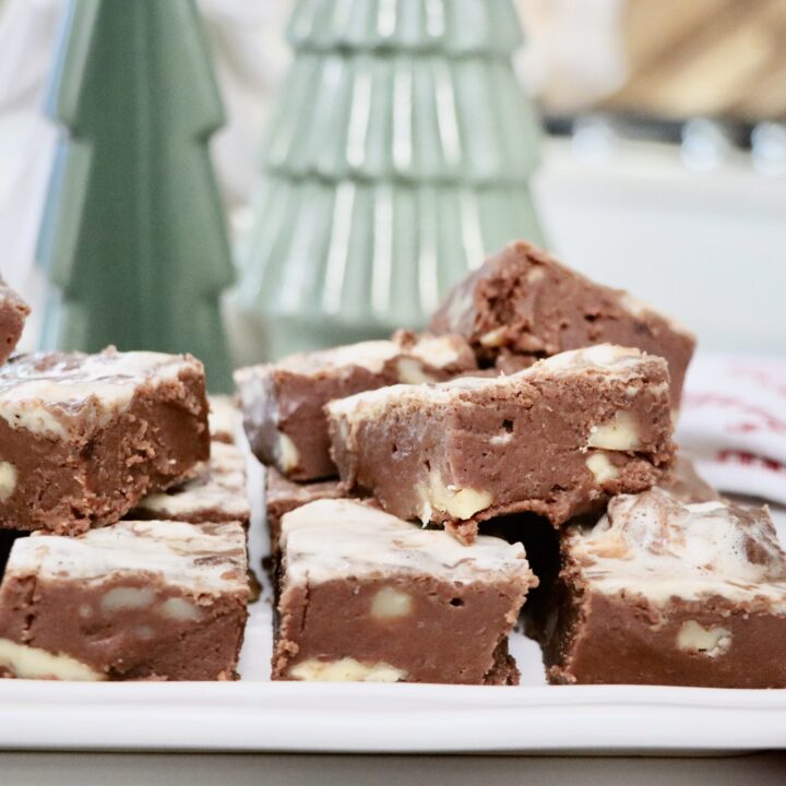 Homemade honey maple marshmallow fudge with walnuts cut into squares on a white tray — rich, creamy, and made from scratch.
