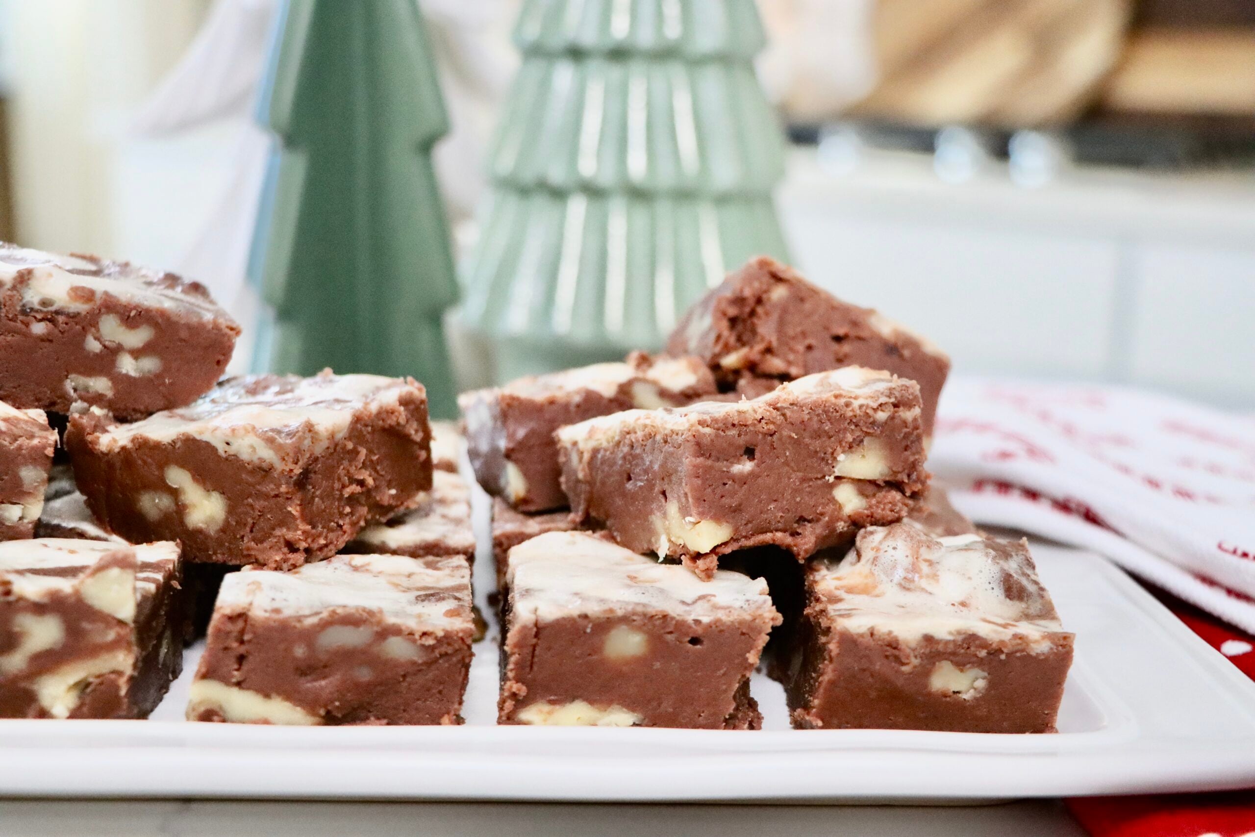 Homemade honey maple marshmallow fudge with walnuts cut into squares on a white tray — rich, creamy, and made from scratch.