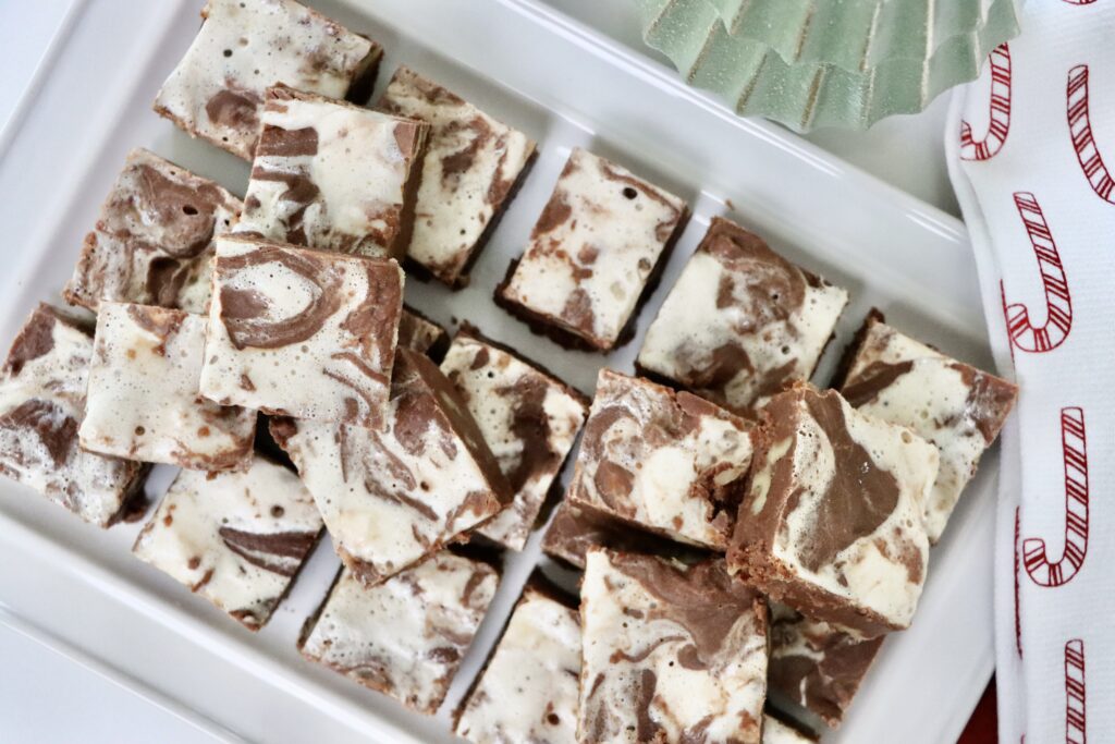 Homemade honey maple marshmallow fudge with walnuts cut into squares on a white tray — rich, creamy, and made from scratch.