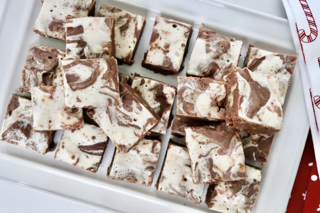 Homemade honey maple marshmallow fudge with walnuts cut into squares on a white tray — rich, creamy, and made from scratch.