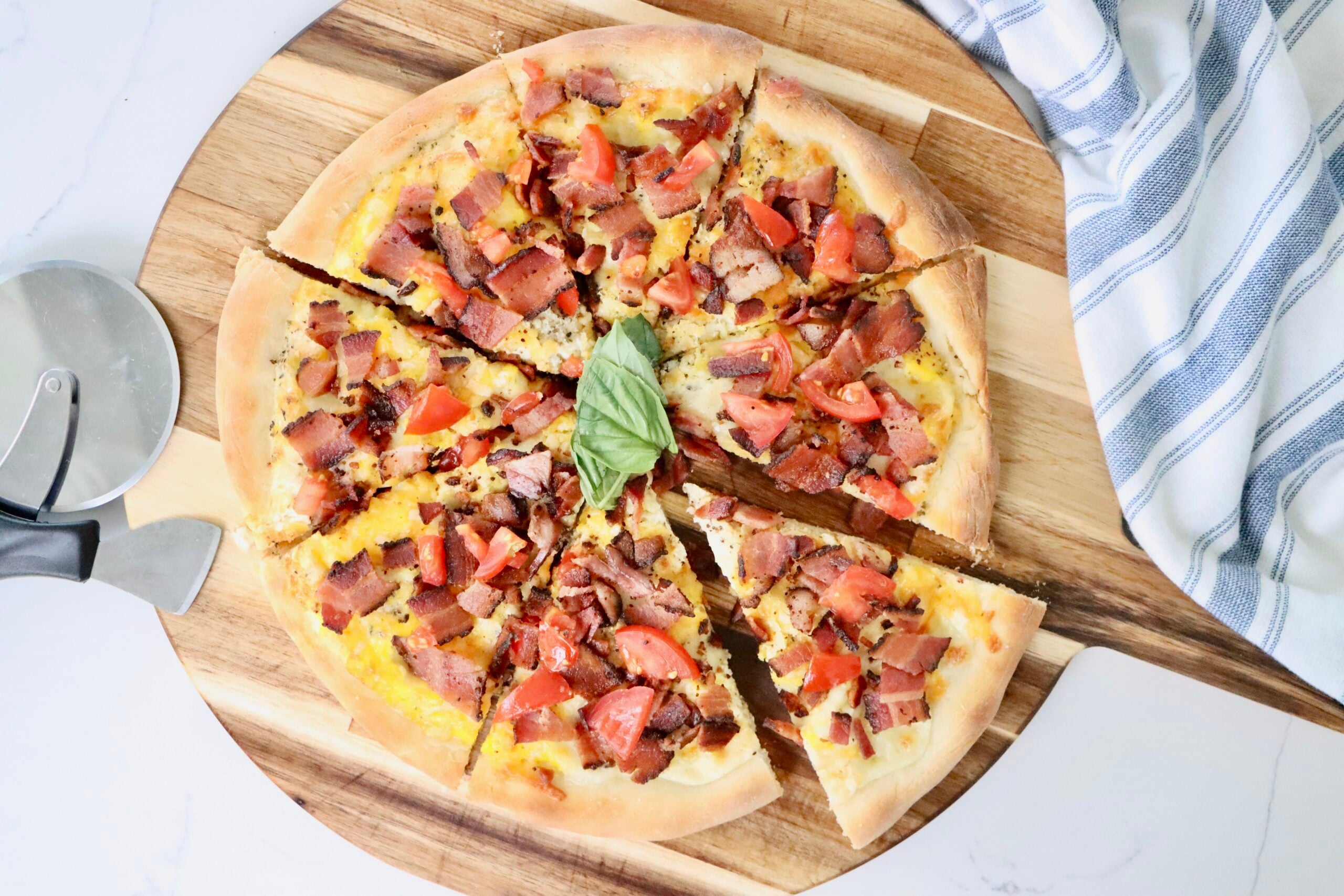 Homemade breakfast pizza baked on sourdough crust with eggs, crispy bacon, and melted cheese