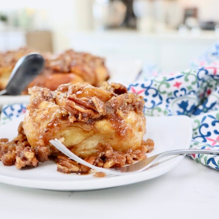 Golden brown sourdough cinnamon rolls baked in a caramel pecan sauce and arranged on a serving tray for breakfast.