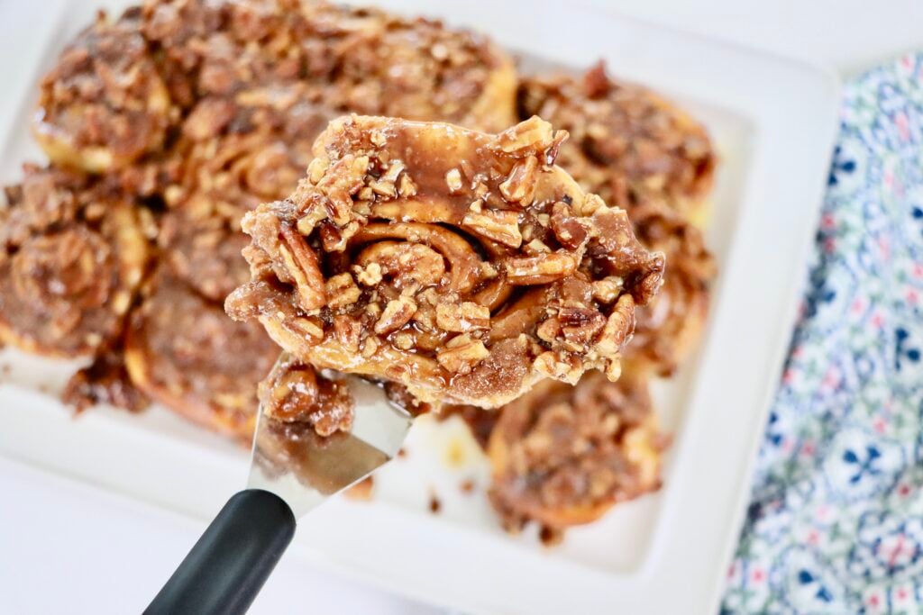 Golden brown sourdough cinnamon rolls baked in a caramel pecan sauce and arranged on a serving tray for breakfast.