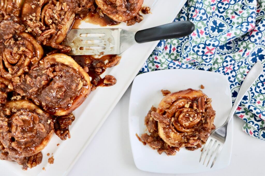 Golden brown sourdough cinnamon rolls baked in a caramel pecan sauce and arranged on a serving tray for breakfast.