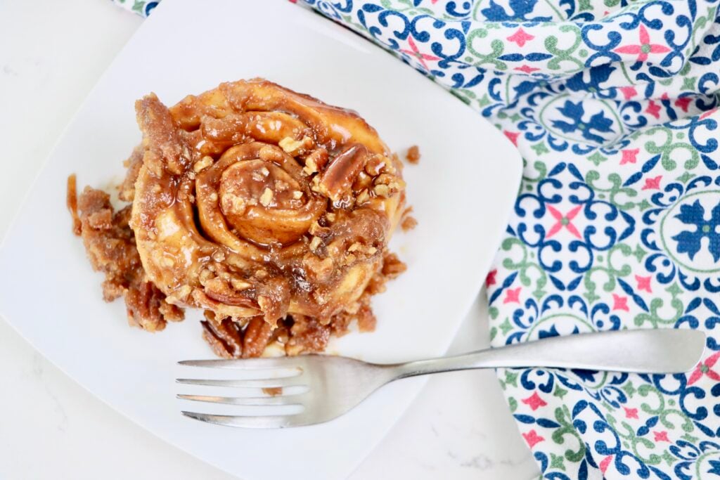 Golden brown sourdough cinnamon rolls baked in a caramel pecan sauce and arranged on a serving tray for breakfast.