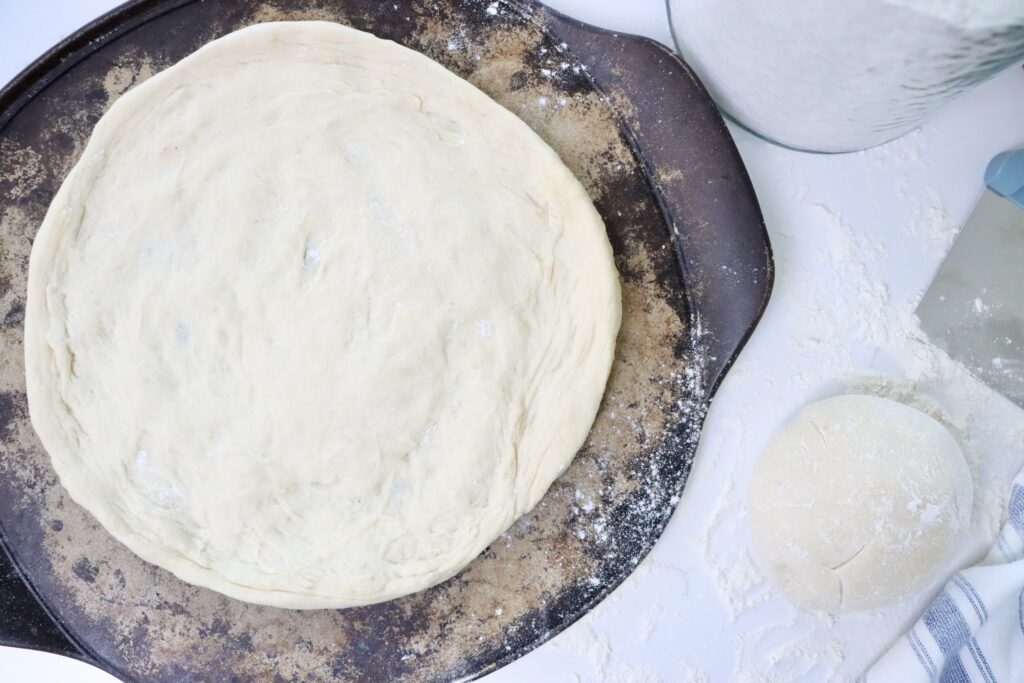 Fermented sourdough pizza dough resting and then shaped into homemade pizza crust