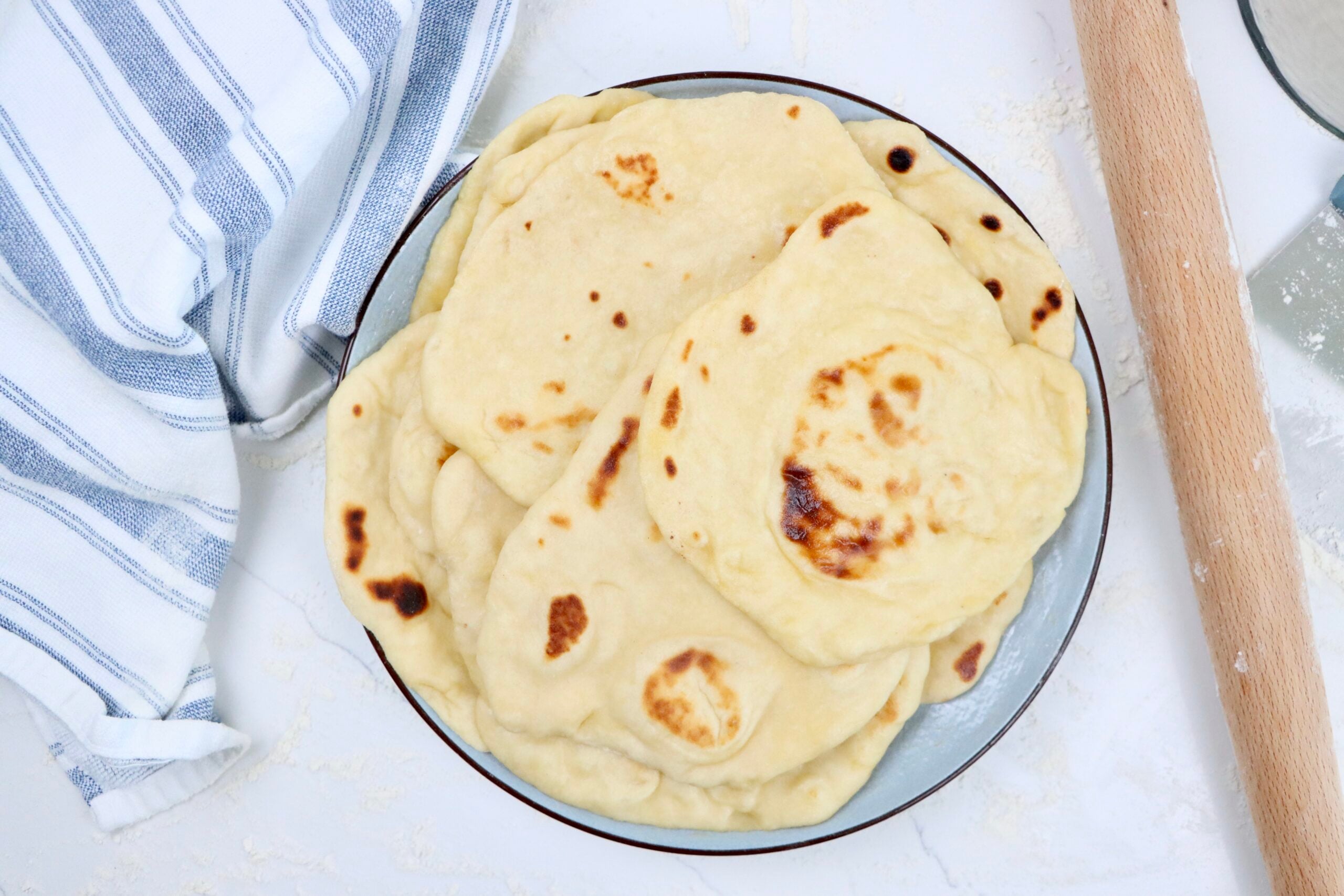 Stack of soft and chewy sourdough naan bread brushed with melted butter