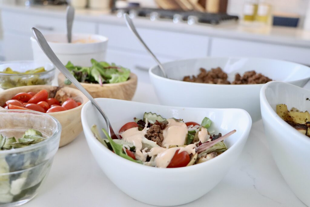 Healthy burger bowl made with ground beef, roasted potatoes, and fresh vegetables