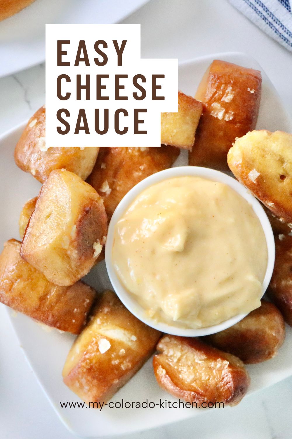 Soft sourdough pretzels served with a creamy homemade cheese sauce, perfect for dipping, freshly baked and golden brown.