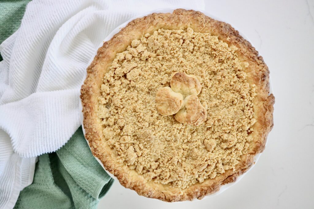 Homemade Dutch Apple Pie with golden crumb topping and thick cinnamon apple filling, fresh from the oven.