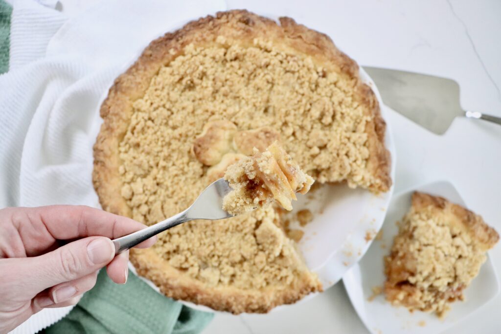 Homemade Dutch Apple Pie with golden crumb topping and thick cinnamon apple filling, fresh from the oven.
