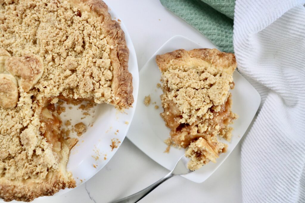 Homemade Dutch Apple Pie with golden crumb topping and thick cinnamon apple filling, fresh from the oven.