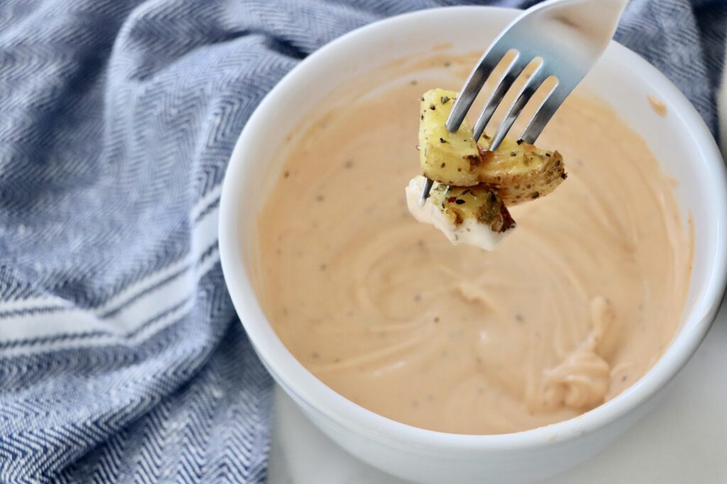 Creamy homemade fry sauce being used as a dipping sauce for crispy french fries.
