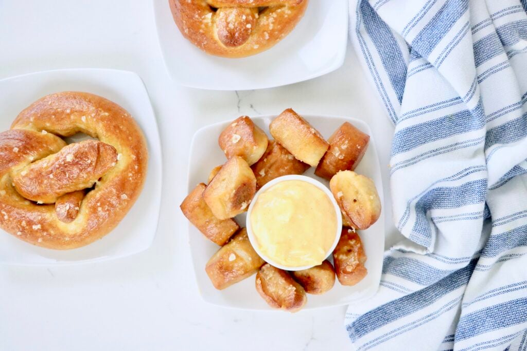 Soft sourdough pretzels served with a creamy homemade cheese sauce, perfect for dipping, freshly baked and golden brown.