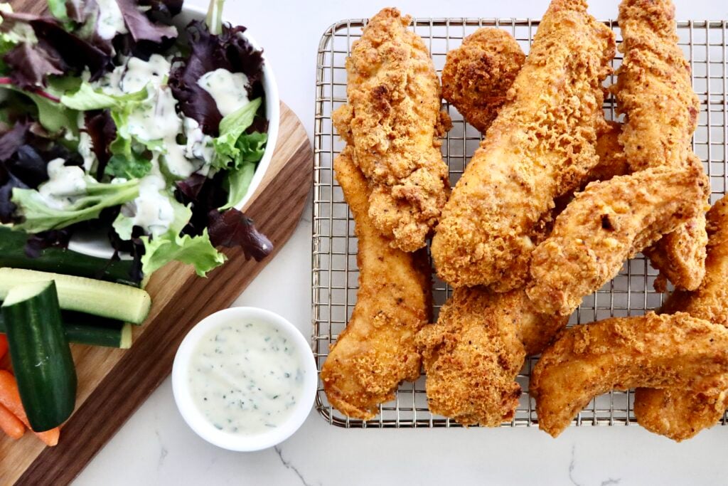 Crispy oven baked chicken tenders with a golden crunchy coating served with dipping sauce.