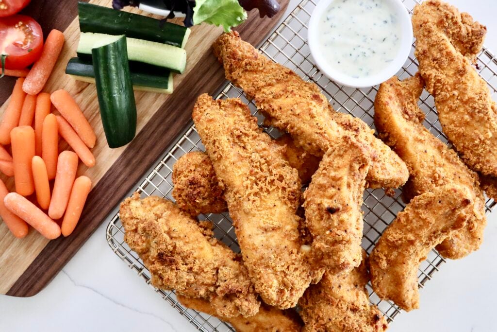 Crispy oven baked chicken tenders with a golden crunchy coating served with dipping sauce.