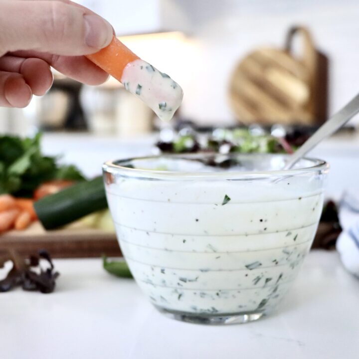 Creamy homemade ranch dressing in a small glass bowl with fresh herbs