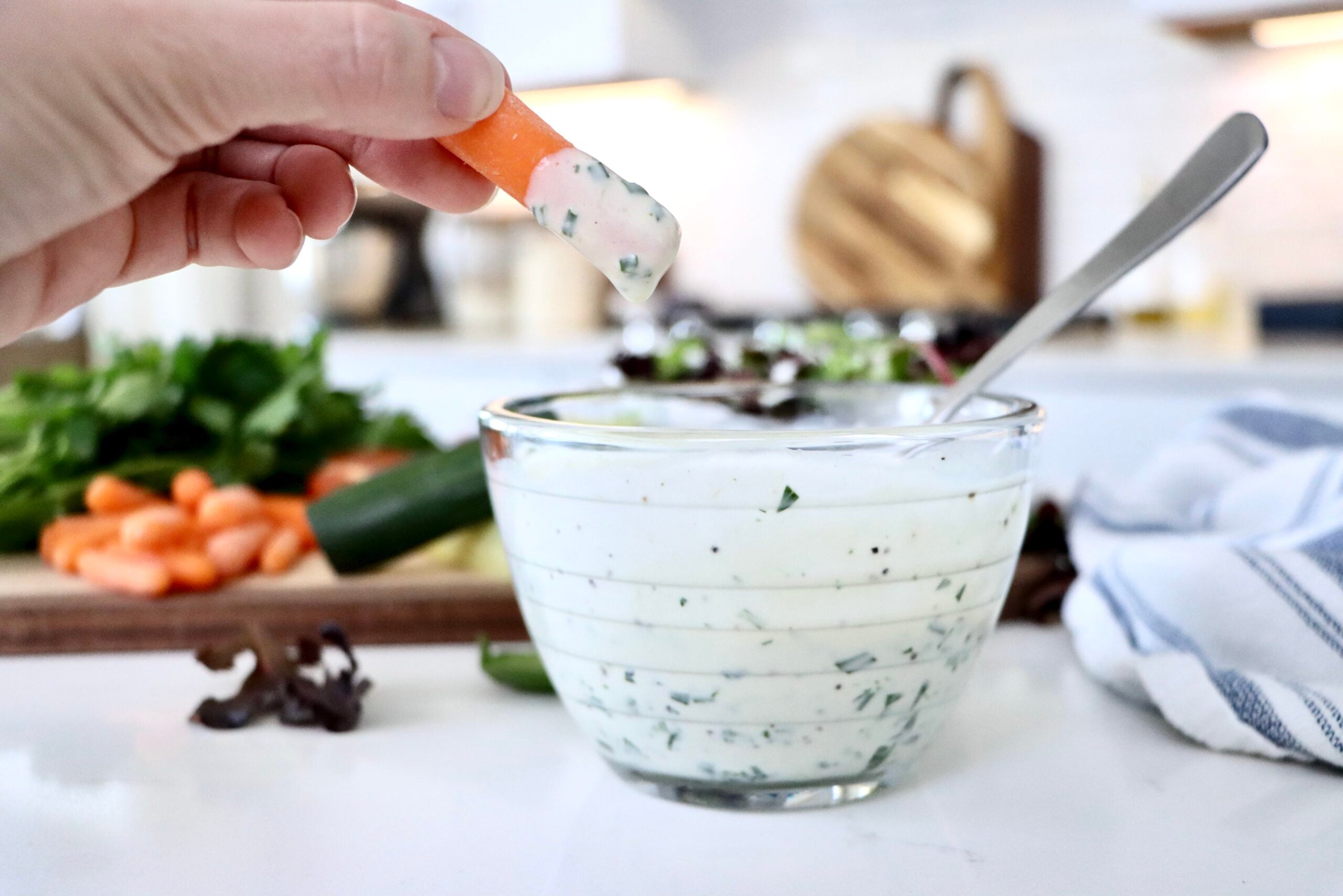 Creamy homemade ranch dressing in a small glass bowl with fresh herbs