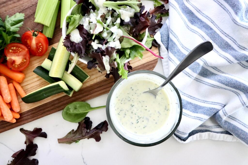 Creamy homemade ranch dressing in a small glass bowl with fresh herbs
