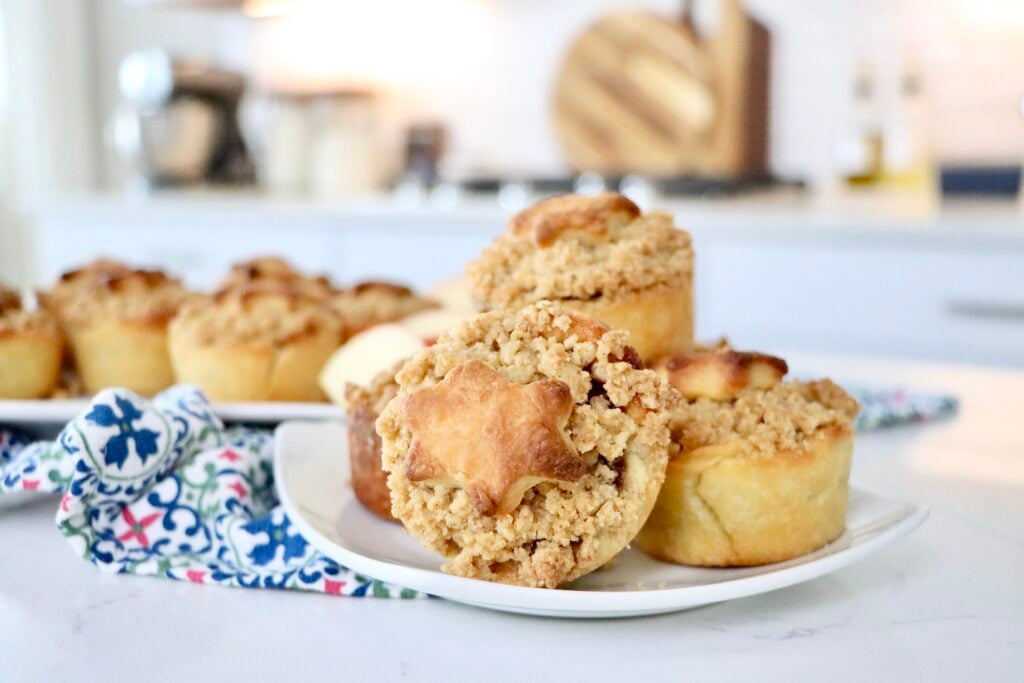 Mini Dutch Apple Pie with decorative crust shapes on top, showing soft cinnamon apple filling inside