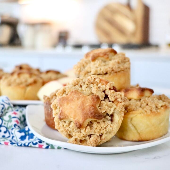 Mini Dutch Apple Pie with decorative crust shapes on top, showing soft cinnamon apple filling inside